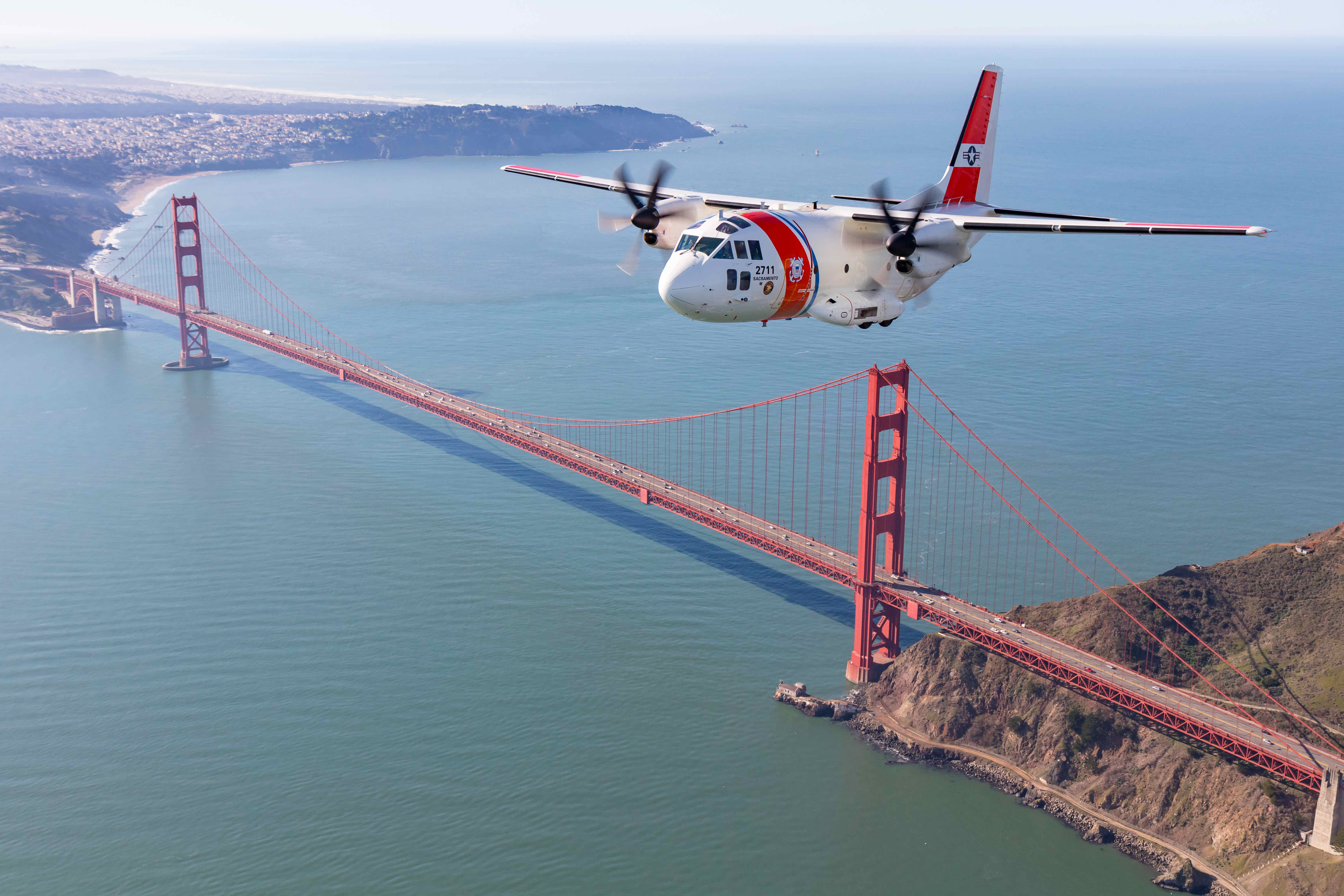 Coast Guard Spartan aircraft in front of Golden Gate Bridge.